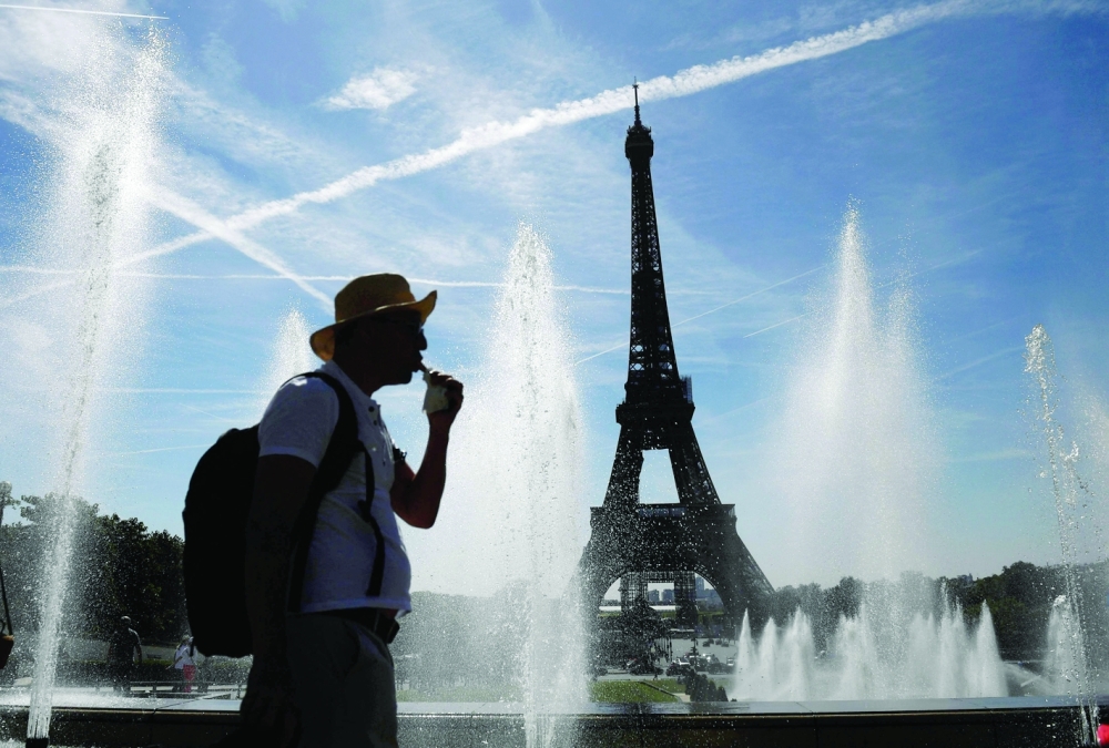 A man cools off by the Trocadero fountains, amid high temperatures in Paris on Thursday. - AFP