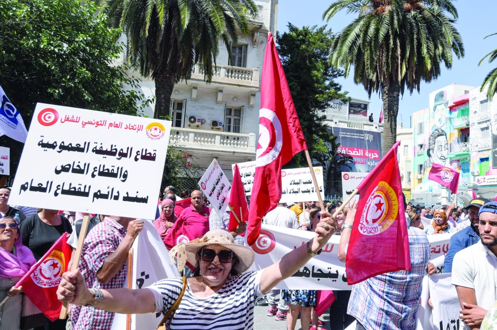 Supporters of the Tunisian General Labour Union gather with national flags during a rally outside its headquarters in the capital Tunis on Thursday amidst a general strike announced by it. - AFP