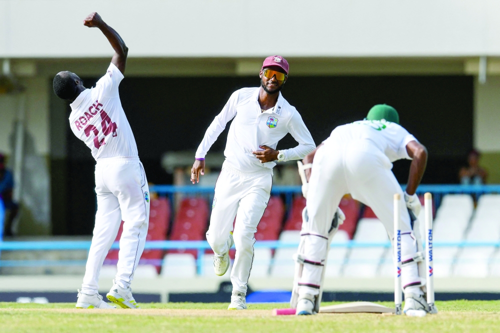 Kemar Roach (L) and Kraigg Brathwaite (C), of West Indies, celebrate the dismissal of Ebadot Hossain Chowdhury (R), of Bangladesh, during the third day of the 1st Test between Bangladesh and West Indies at Vivian Richards Cricket Stadium in North Sound, Antigua and Barbuda. — AFP