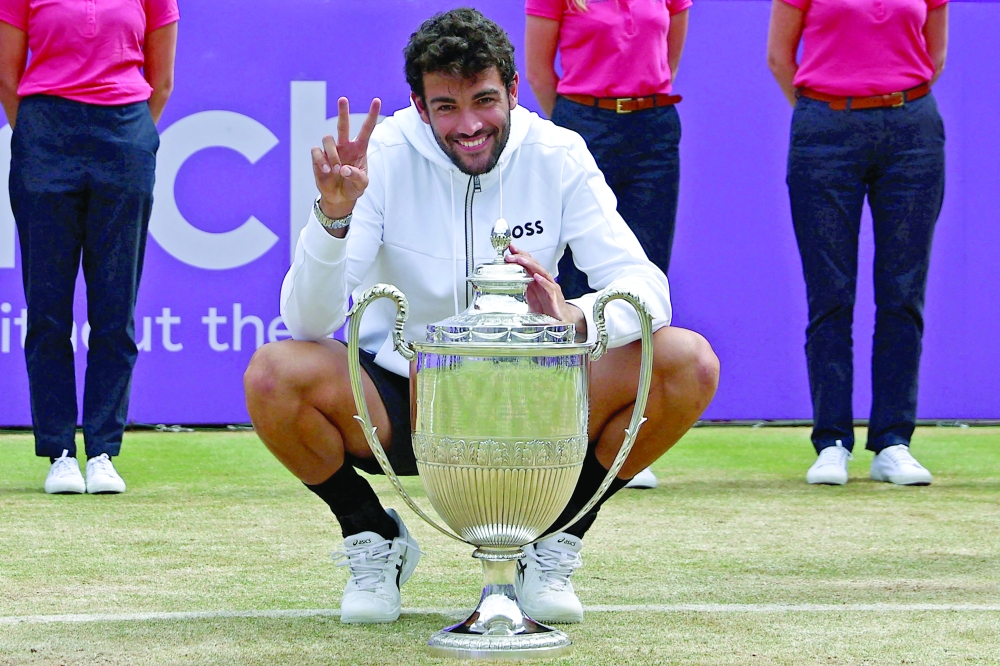 Italy's Matteo Berrettini poses for a photograph as he celebrates with the trophy. -- AFP