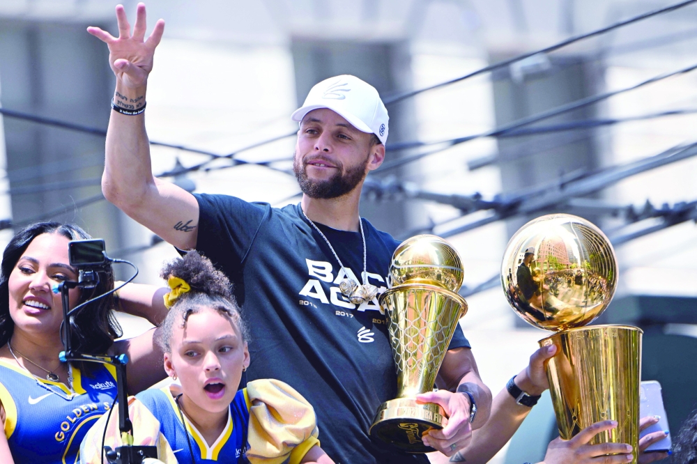 US basketball player Stephen Curry (C) holds the MVP trophy. -- AFP