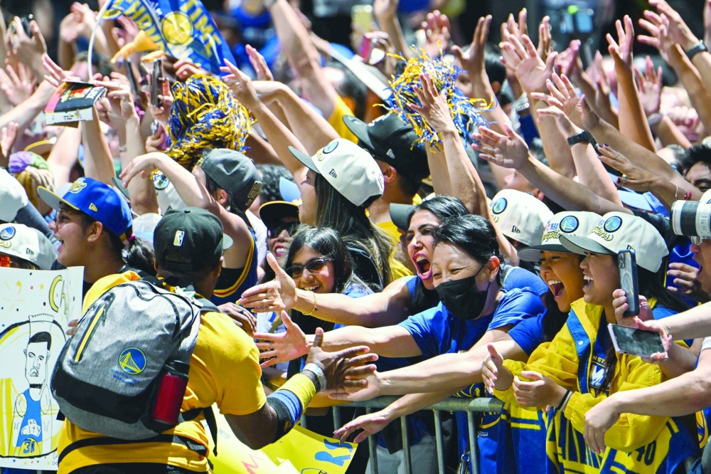 Basketball fans cheer during the Golden State Warriors NBA Championship victory parade. -- AFP