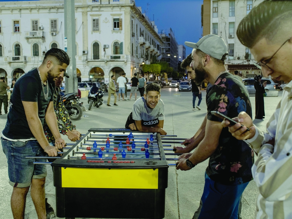 Friends play a game in Martyr Square in Tripoli.