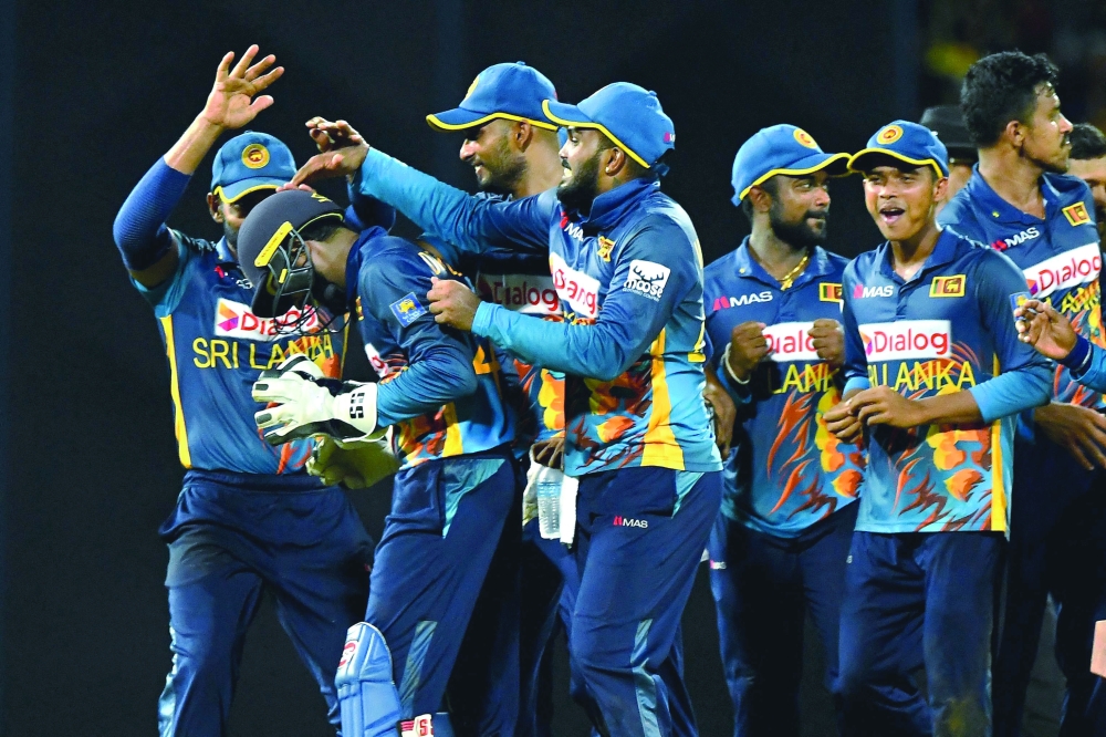 Sri Lanka's wicketkeeper Niroshan Dickwella (2nd L) celebrates with team-mates. -- AFP