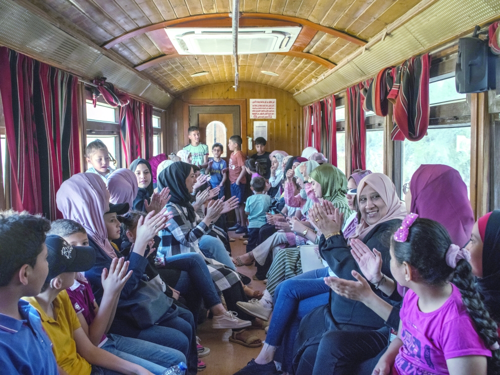Women and children clap along to an Arabic pop song in train car No 9 at the start of the trip from Amman.  