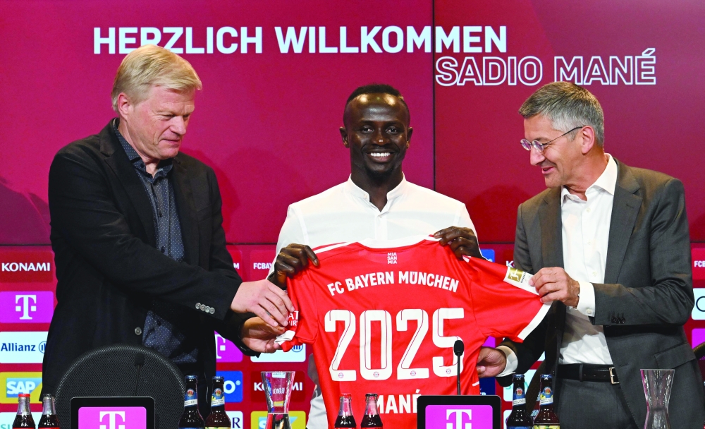 Bayern Munich's Sadio Mane (C) with his jersey poses next to Bayern Munich CEO Oliver Kahn (L) and President Herbert Hainer during a press conference. -- AFP