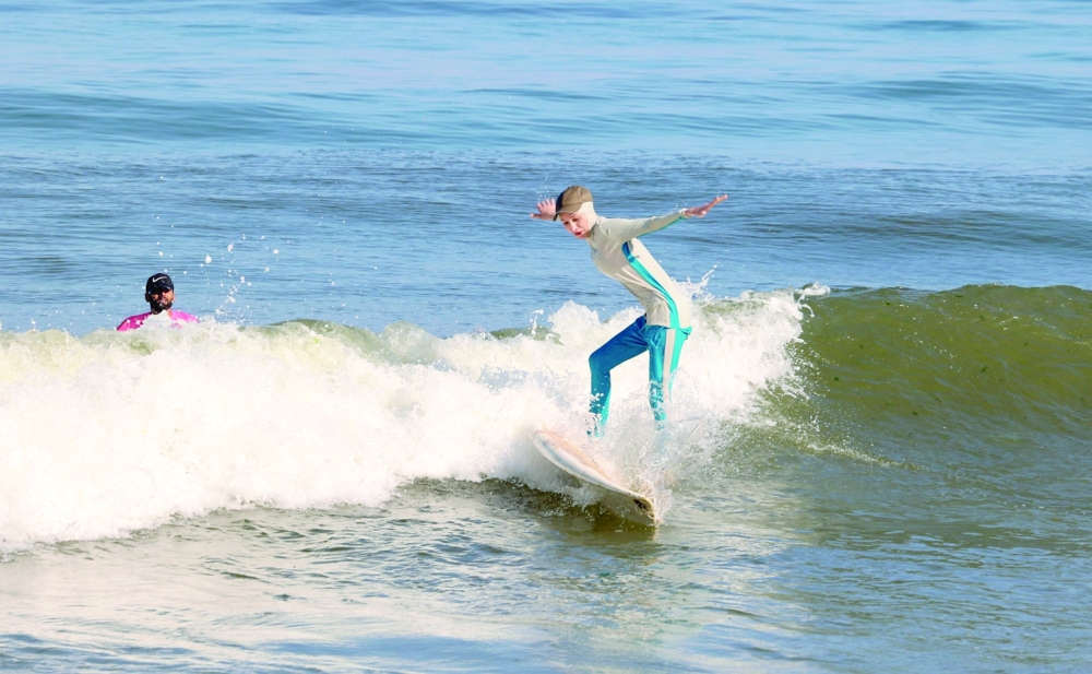 Sabah Abu Ghanem, a 22-year-old Palestinian surfer, trains with her brother off the shore of Gaza City. - AFP