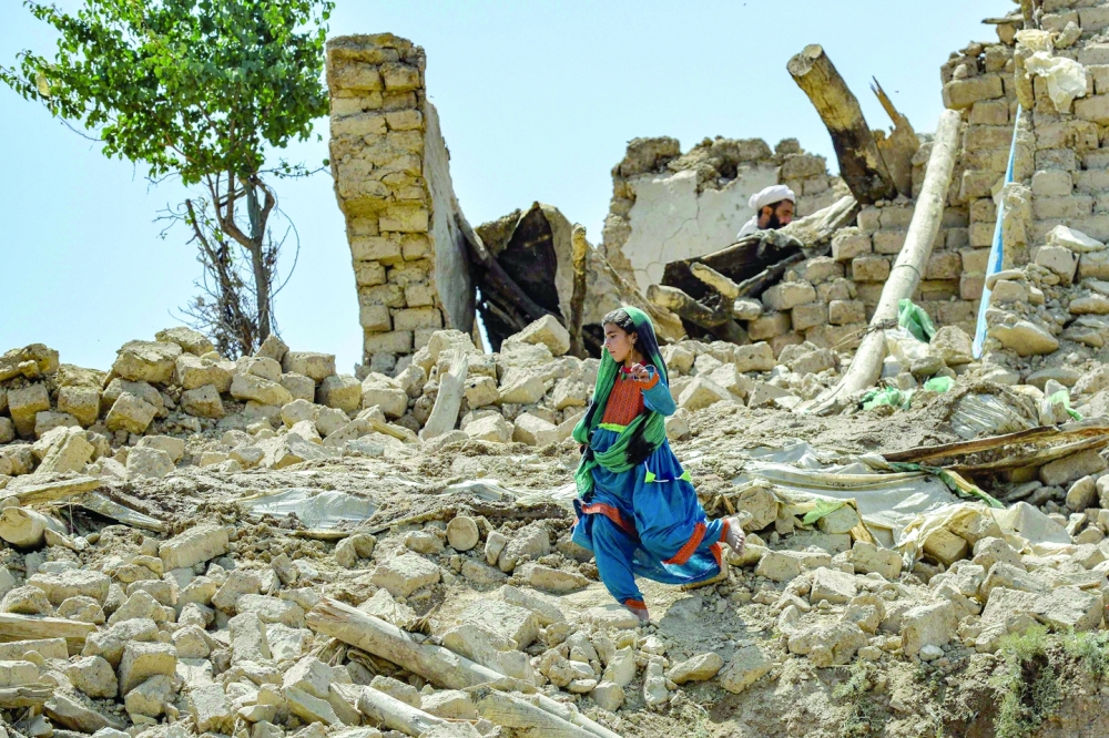 A child walks amidst the rubble of damaged houses following an earthquake in Bermal district, Paktika province. - AFP