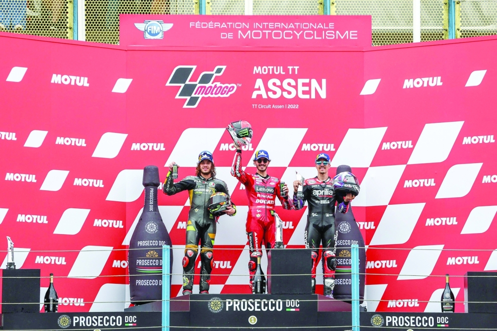 Italy's rider Marco Bezzecchi (L), Italy's Francesco Bagnaia and Spain's Maverick Vinales celebrate after Dutch MotoGP race at the TT circuit in Assen. 
—  AFP