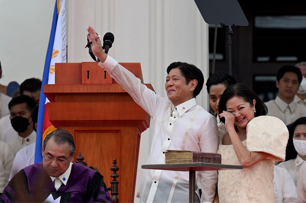 New Philippine President Ferdinand Marcos Jr. (C) waves to supporters as his wife Louise (R) reacts after taking the oath as president during his inauguration ceremony at the National Museum in Manila on June 30, 2022.