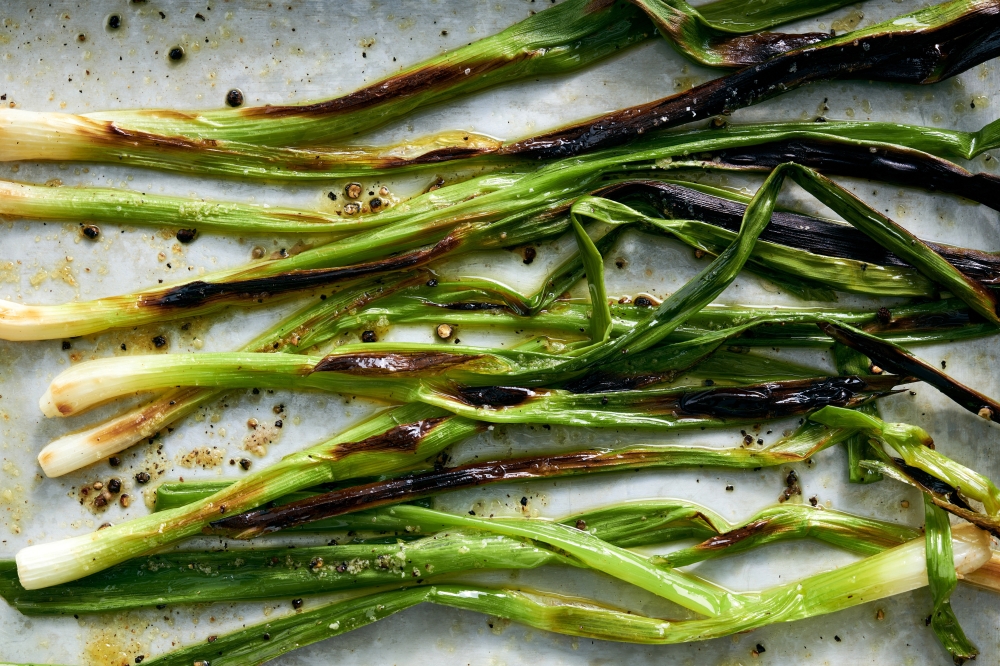 Scallions roasted for a tahini potato salad in New York, June 8, 2022. Food styled by Simon Andrews. (David Malosh/The New York Times)