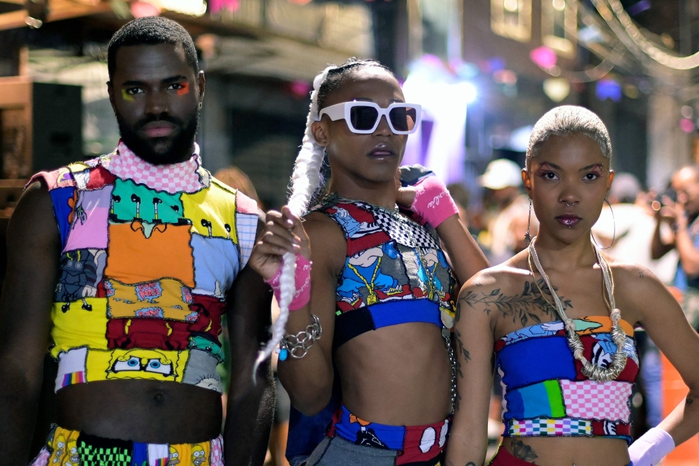 Members of the 'La da Favelinha' project pose for a picture during the Favelinha Fashion Week in Vila Santana do Cafezal, Aglomerado da Serra in Belo Horizonte, Minas Gerais State, Brazil on June 26, 2022.  The event presents a new way of making fashion focused on innovation, cultural diversity and principles of sustainability, and all the pieces were made with leftover socks and jeans and created by stylists and seamstresses from the community itself. The event also served to publicize an action by La da Favelinha, where they make and donate 100 sustainable sanitary pads to women from schools in the region. (Photo by DOUGLAS MAGNO / AFP)
