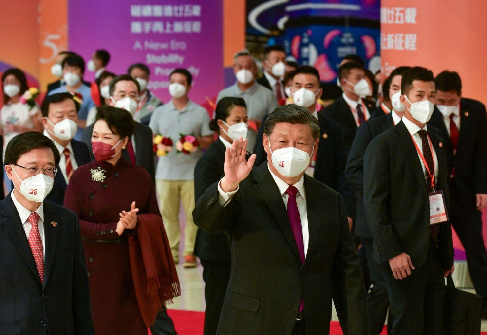 Chinese President Xi Jinping, accompanied by new Hong Kong Chief Executive John Lee, waves goodbye to people seeing him off at the West Kowloon railway station, on Friday. - Reuters