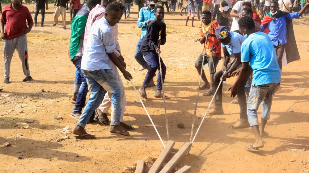 Protesters try to block the road during a rally against military rule, following the last coup and to commemorate the 3rd anniversary of revolution, in Khartoum, on Friday. - Reuters