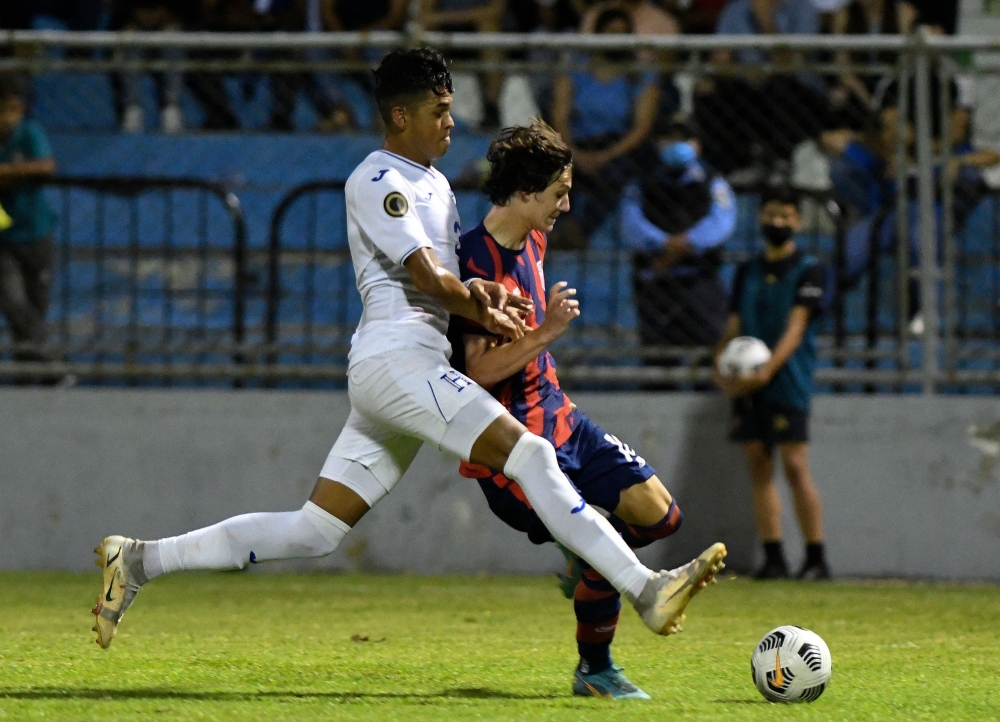 Paxten Aaronson (R) of the USA vies for the ball with Geremy Rodas (L) of Honduras during their Concacaf U-20 World Cup semifinal football match at the General Francisco Morazan stadium in San Pedro Sula, Honduras, on July 1, 2022.  (Photo by Orlando SIERRA / AFP)

