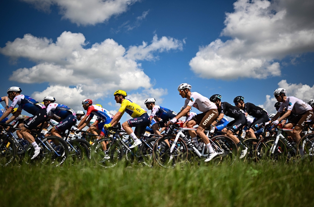 Quick-Step Alpha Vinyl Team's Belgian rider Yves Lampaert wearing the overall leader's yellow jersey (C) cycles with the pack of riders during the 2nd stage of the 109th edition of the Tour de France cycling race, 202,2 km between Roskilde and Nyborg, in Denmark. —  AFP