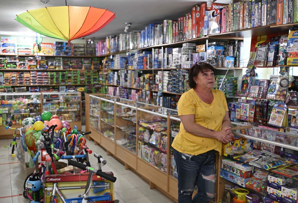 Viktoria Miroshnichenko, 54, answers AFP journalists' questions at a toys shop in Kramatorsk, amid the Russian invasion of Ukraine on July 2, 2022. 