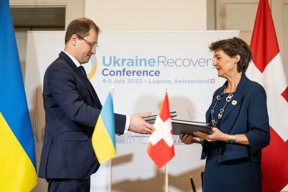 Swiss Environment, Energy and Transport Minister Simonetta Sommaruga and Ukranian Minister of Environmental Protection and Natural Resources Ruslan Strilets exchange documents after signing an Implementing Agreement between the Swiss Federal Council and Ukraine in Lugano. — AFP