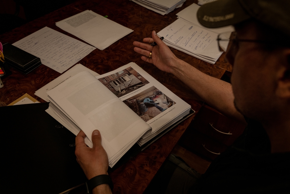 Andriy Andriychuk, who joined the police force in the region west of Kyiv two years ago, looks through files documenting potential war crimes, at his office in Kharkiv, Ukraine, May 29, 2022. (Nicole Tung/The New York Times)
