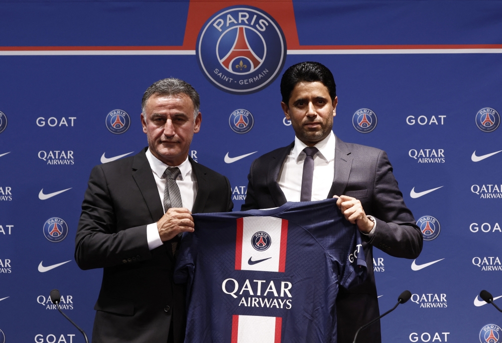 The new PSG coach Christophe Galtier is presented with the club jersey by PSG president Nasser Al-Khelaifi, during the press conference. -- Reuters