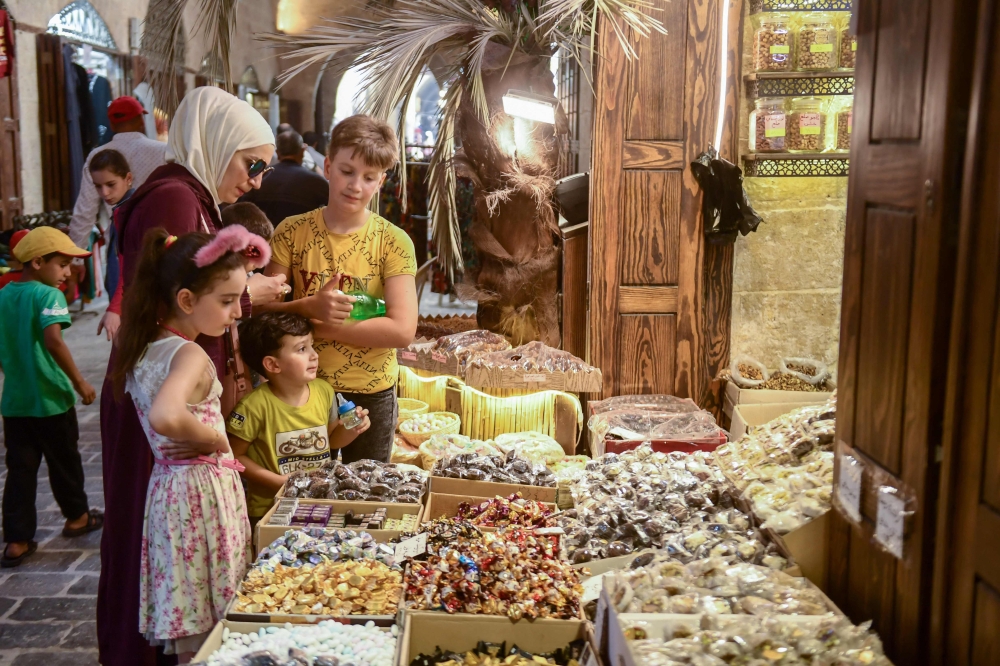 Syrians shop at the old market in the northern city of Aleppo ahead of the Eid al Adha festival and holiday. - AFP