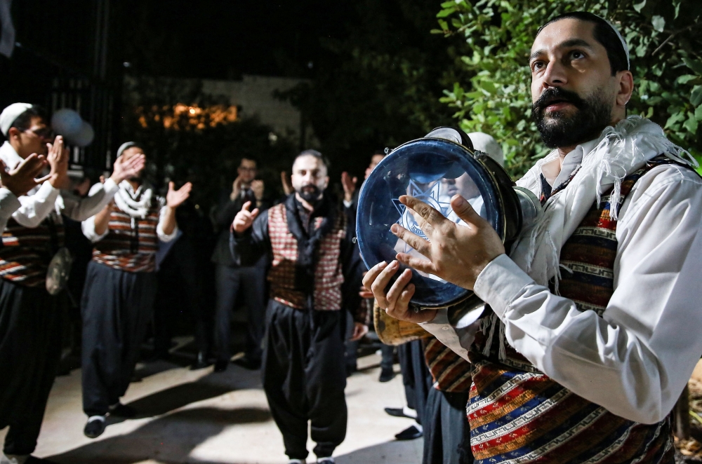 Syrian 'Arada' folklore dancers of the 'Bab al Hara" troupe perform while in traditional garb during a celebration for the graduation of two of the sons of one of their members, Fahed Shehadeh, from universities, in Jordan's capital Amman. - AFP