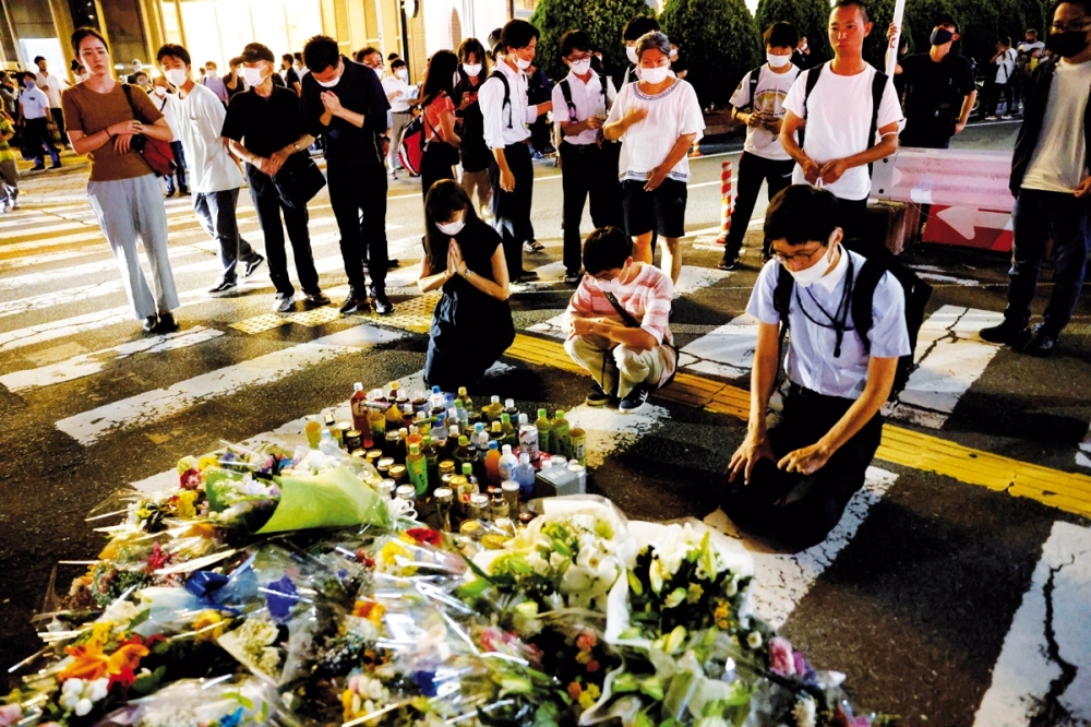 People pay respects at the site where Shinzo Abe was shot while campaigning for a parliamentary election, near Yamato-Saidaiji station in Nara. — Reuters