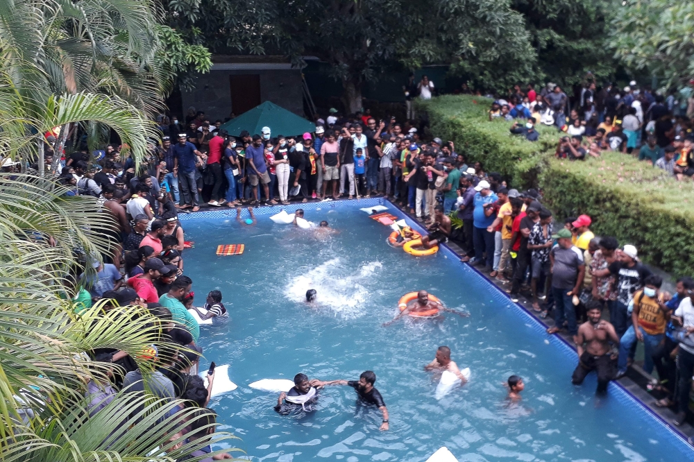 Protesters demanding the resignation of Sri Lanka's President Gotabaya Rajapaksa swim in a pool inside the compound of Sri Lanka's Presidential Palace in Colombo on Saturday.  — AFP