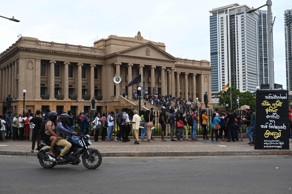 People line up to visit presidential secretariat in Colombo after it was overrun by anti-government protestors. - AFP
