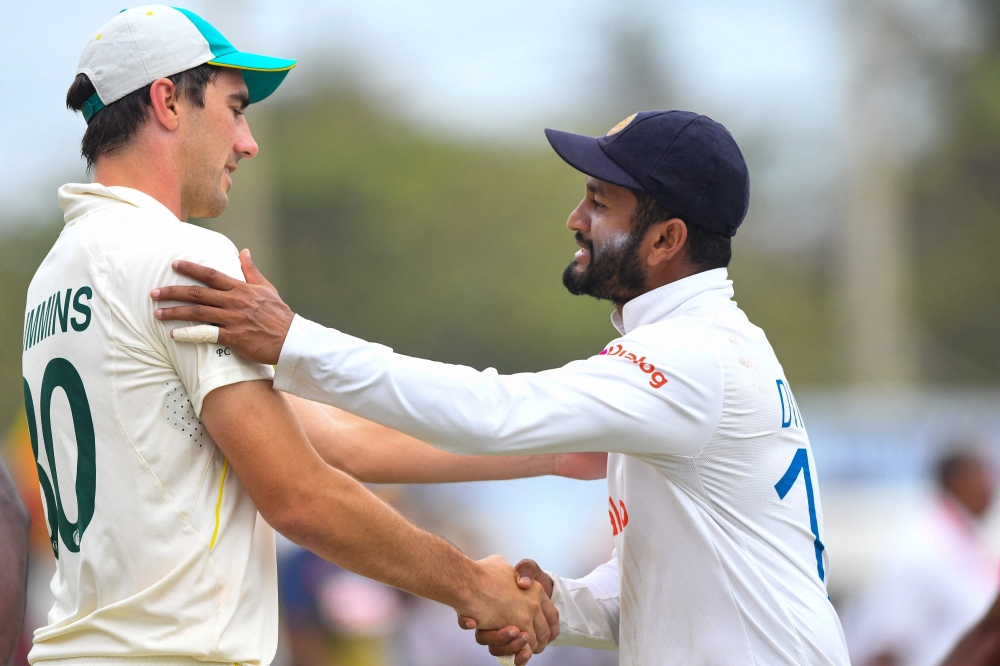 Sri Lanka's captain Dimuth Karunaratne (R) shakes hands with his Australian counterpart Pat Cummins at the end of the second Test. -- AFP