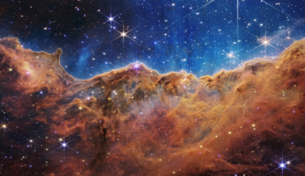 This landscape of “mountains” and “valleys” speckled with glittering stars is actually the edge of a nearby, young, star-forming region called NGC 3324 in the Carina Nebula. Captured in infrared light by NASA’s new James Webb Space Telescope, this image reveals for the first time previously invisible areas of star birth.
Credits: NASA, ESA, CSA, and STScI