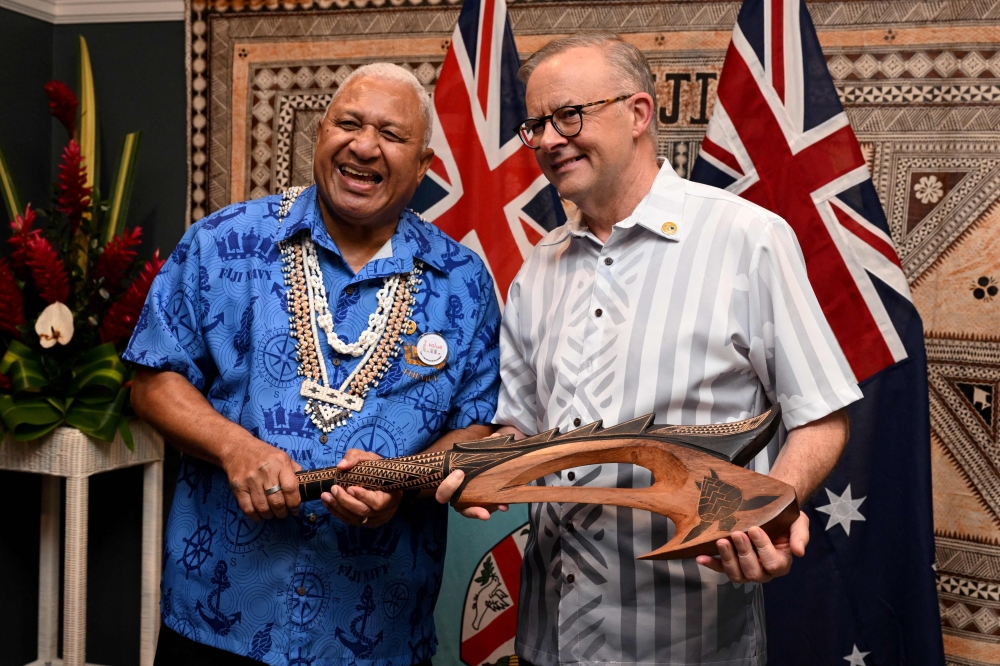 Fiji Prime Minister Frank Bainimarama presents Australian Prime Minister Anthony Albanese (R) with a Wau war club during a bilateral meeting in Suva. —  AFP