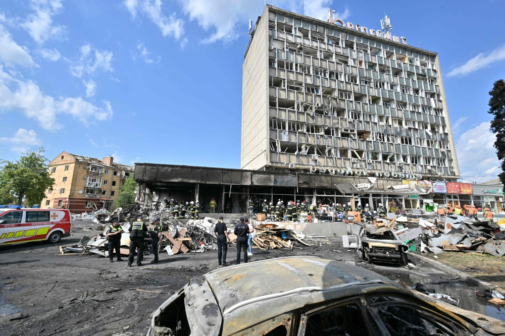 Firefighters inspect a damaged building following a Russian airstrike in which at least 20 people were killed in the city of Vinnytsia, west-central Ukraine, on Thursday. -- AFP