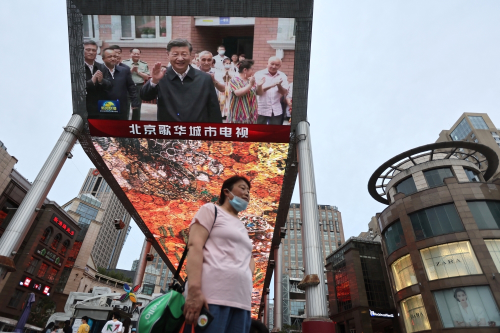 A giant screen shows news footage of Chinese President Xi Jinping visiting Xinjiang Uyghur Autonomous Region, at a shopping centre, in Beijing, on Friday. - Reuters