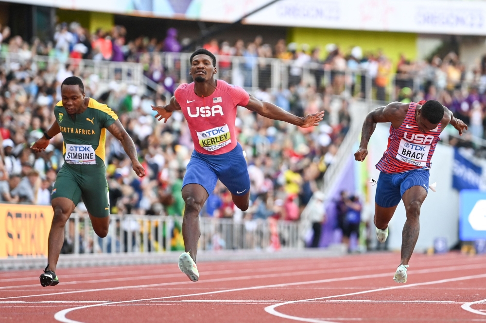 TOPSHOT - (From L) South Africa's Akani Simbine, USA's Fred Kerley and USA's Marvin Bracy cross the finish line in the men's 100m final during the World Athletics Championships at Hayward Field in Eugene, Oregon on July 16, 2022.  (Photo by Jewel SAMAD / AFP)

