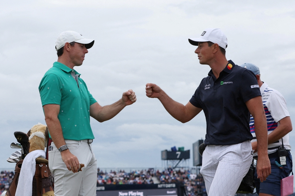 Golf - The 150th Open Championship - Old Course, St Andrews, Scotland, Britain - July 16, 2022 Northern Ireland's Rory McIlroy and Norway's Viktor Hovland celebrate on the 10th during the third round after scoring an eagle and a birdie respectively REUTERS/Paul Childs     TPX IMAGES OF THE DAY
