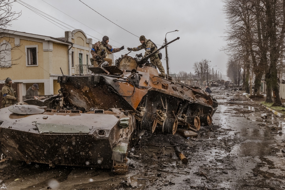 Ukrainian soldiers salvage parts from a destroyed Russian military vehicle in Bucha, Ukraine. 