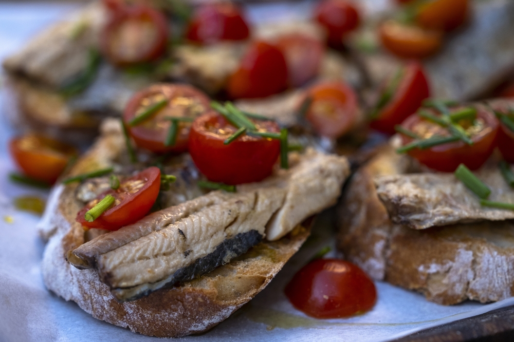 Sardines on toast with fresh tomatoes at Aduela, a bar in Porto, Portugal, July 4, 2022. (Daniel Rodrigues/The New York Times)