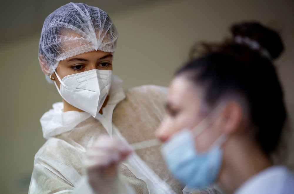 A medical worker administers a nasal swab to a patient at a coronavirus disease Covid-19 testing centre in Les Sorinieres, near Nantes, France. — Reuters 