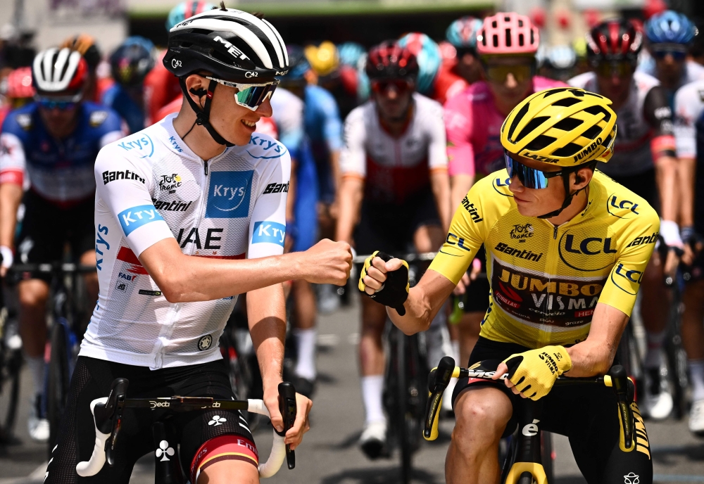 UAE Team Emirates team's Slovenian rider Tadej Pogacar wearing the best young rider's white jersey (L) fist bumps Jumbo-Visma team's Danish rider Jonas Vingegaard wearing the overall leader's yellow jersey (R) as they await the start of the the 17th stage of the 109th edition of the Tour de France cycling race, 129,7 km between Saint-Gaudens and Peyragudes, in southwestern France, on July 20, 2022. (Photo by Marco BERTORELLO / AFP)


