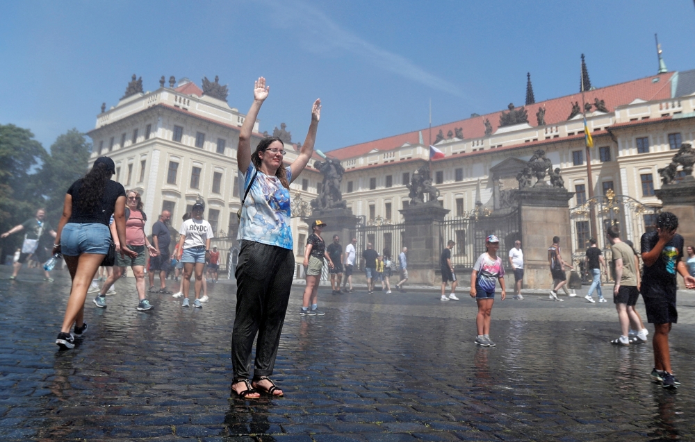 People are sprayed with water to cool down as temperature hovered over 34 degrees Celsius (93.2 degrees Fahrenheit), in Prague, Czech Republic, July 20, 2022.