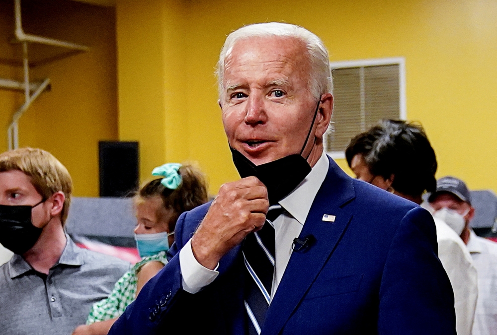 President Joe Biden tugs at his face mask during a visit to a Covid-19 vaccination clinic in Washington. - Reuters file photo