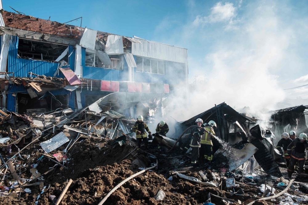 Firefighters extinguish a fire on a local market damaged following a shelling in the town of Bakhmut, eastern Ukraine, on Thursday. — AFP