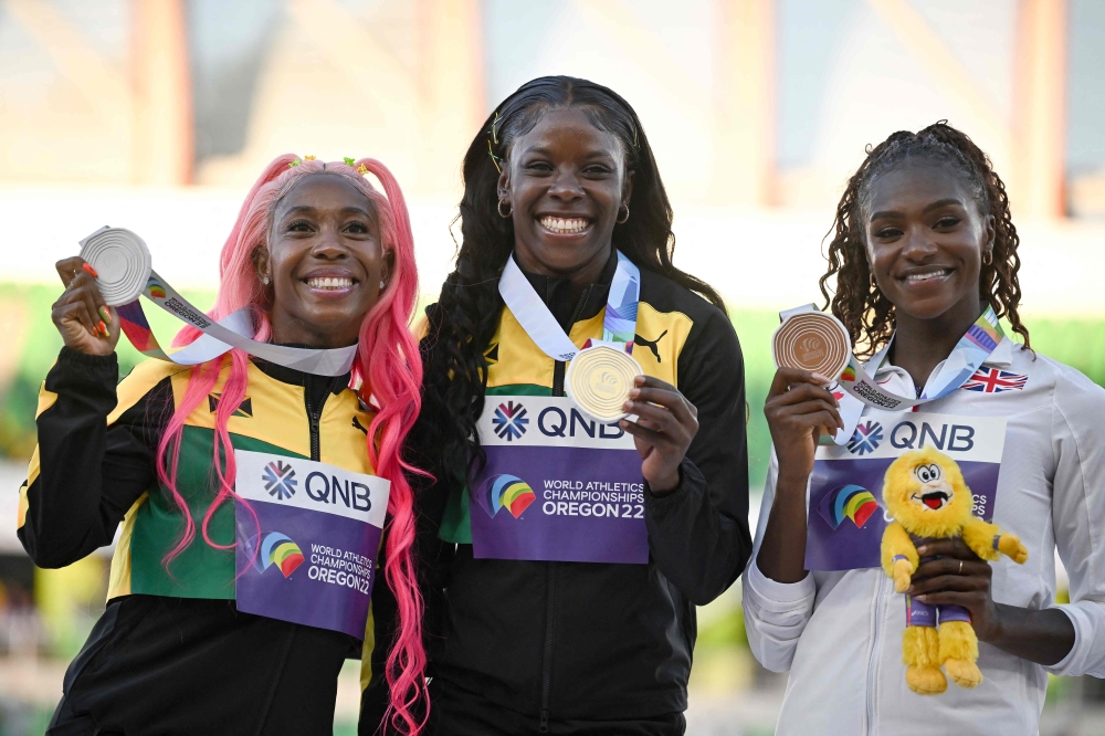 Silver medallist Jamaica's Shelly-Ann Fraser-Pryce (L), gold medallist Jamaica's Shericka Jackson (C) and bronze medallist Britain's Dina Asher-Smith (R) pose on the podium during the medal ceremony for the women's 200m during the World Athletics Championships in Eugene, Oregon on July 21, 2022. (Photo by Ben Stansall / AFP)

