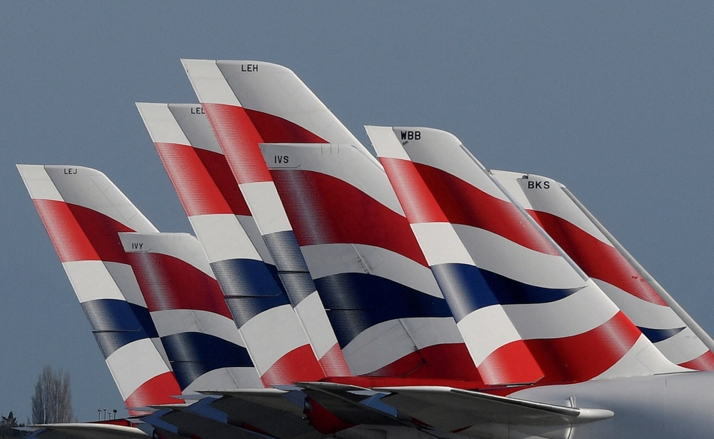 FILE PHOTO: Tail Fins of British Airways planes are seen parked at Heathrow airport as the spread of the coronavirus disease (Covid-19) continues, London, Britain, March 31, 2020. REUTERS/Toby Melville/File Photo