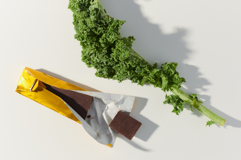 A chocolate bar and a piece of kale, in Los Angeles, July 7, 2022. (Aileen Son/The New York Times)