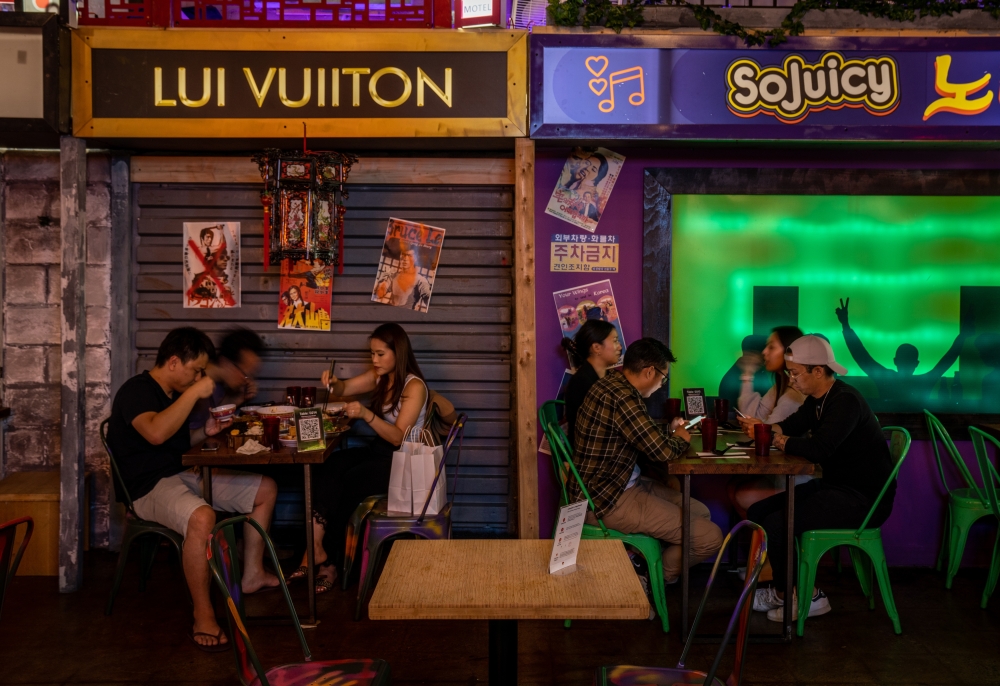 Diners at Superfresh, a showcase for Asian food and drink vendors in a large hall designed to look like an alleyway, in Toronto, June 29, 2022. (Eugen Sakhnenko/The New York Times)