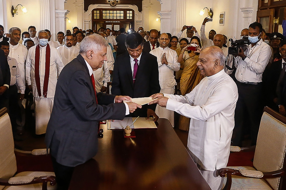 Sri Lakan President Ranil Wickremesinghe (L) swears in Dinesh Gunawardena as the new Prime Minister in Colombo on Friday. - AFP