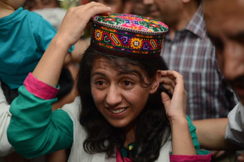 (FILES) In this file photo taken on June 3, 2013 Samina Baig, the first Pakistani woman climber to summit the world's highest peak Mount Everest, gestures on her arrival at Banezir airport in Islamabad.   Pakistan on July 22 celebrated Samina Baig becoming the first woman from the country to summit K2, the world's second highest mountain. (Photo by Farooq NAEEM / AFP)
