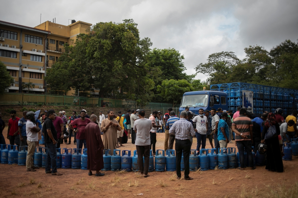 People stand next to their empty cylinders as they wait in a queue to buy domestic cooking gas, amid the country's economic crisis, in Colombo, Sri Lanka, July 23, 2022.